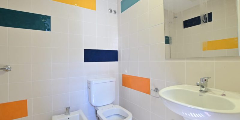 Nuevos pisos de granito y cerámicos blancos en las paredes con detalles en colores para niños en reemplazo de los viejos azulejos de los baños